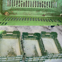 Green plastic crates with visible wear and tear on a textured surface